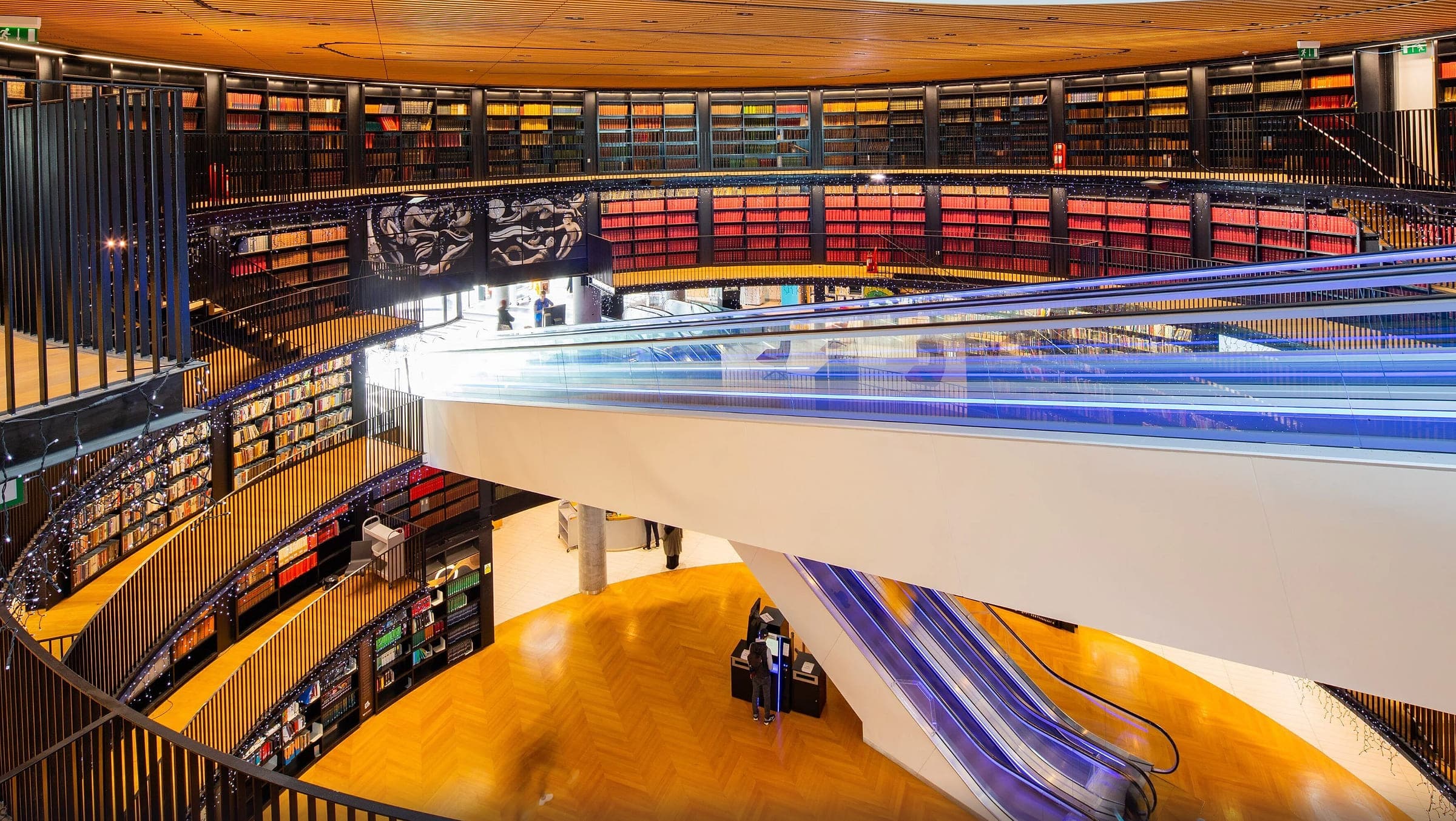 Illuminated escalators crossing the book rotunda in the Library of Birmingham